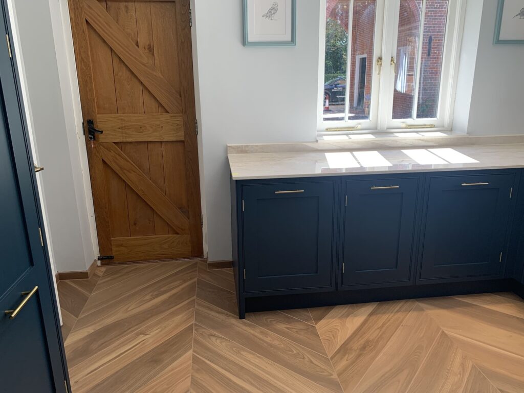Work top and cupboards with herringbone tiled floor