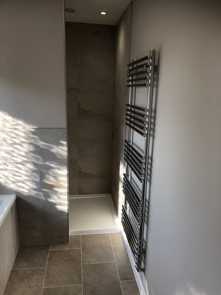 Finished bathroom renovation in East Bergholt, shower and radiator in view